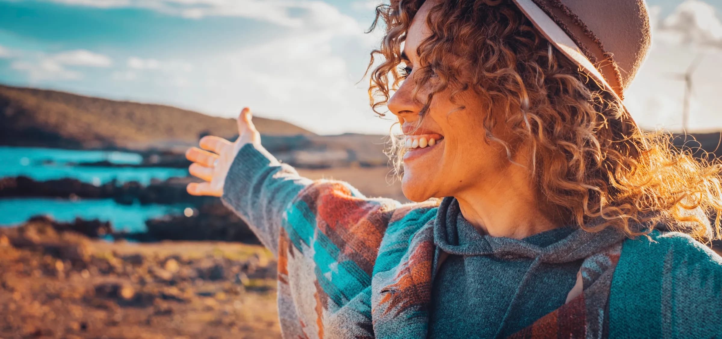 A woman overlooking a coastal landscape at golden hour