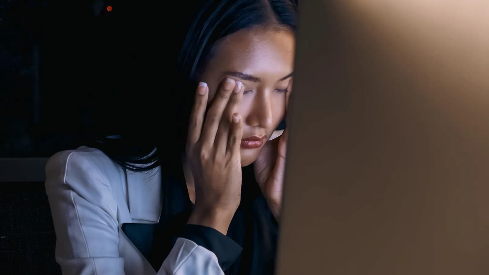 Woman resting with her eyes closed in low light